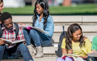 An image of a group of students sitting outside on the steps.