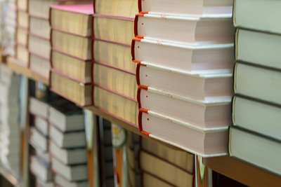 A photo of books stacked on shelves.