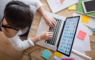 An image of a young woman working on her laptop.