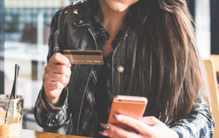 An image of a young woman making a mobile payment.