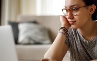 An image of a young woman working on her laptop.